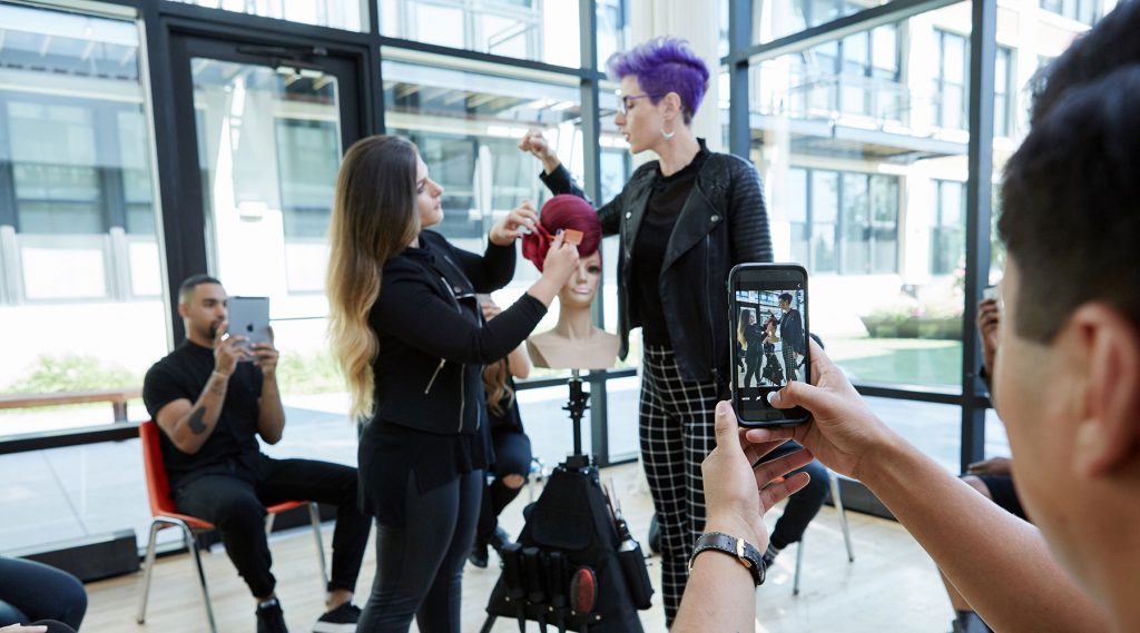 teacher guiding student working on mannequin